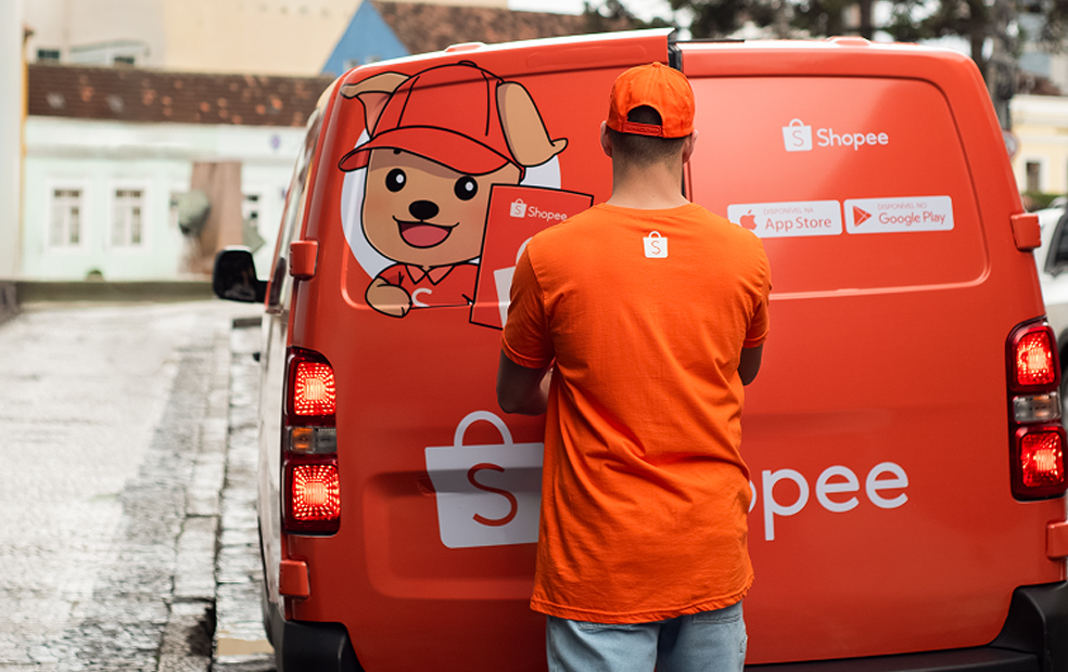Entregador Shopee ao lado de van de logística laranja